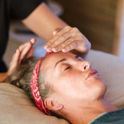 hands hovering about a face: Reiki Healing Course